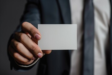 Business Card In Hand. Businessman Holding Blank White Card Closeup