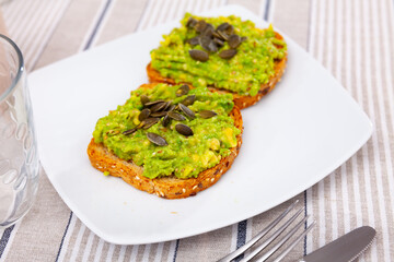 Sandwich with guacamole butter and seeds on whole grain bread, healthy eating concept, top view