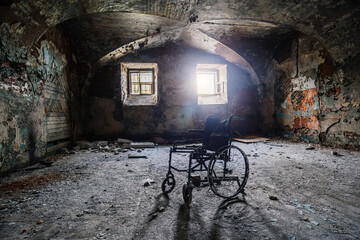 Old derelict wheelchair inside of the abandoned ruined hospital