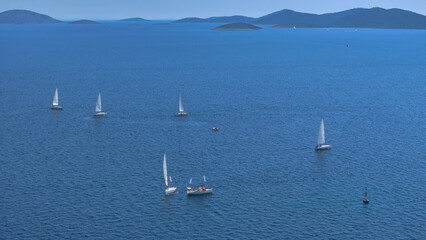 AERIAL: Flying above sailboats sailing the calm Adriatic waters on a sunny day.