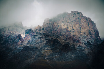 A beautiful rocky mounains in a foggy cloudy weather in the evening.