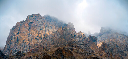 A beautiful rocky mounains in a foggy cloudy weather in the evening.