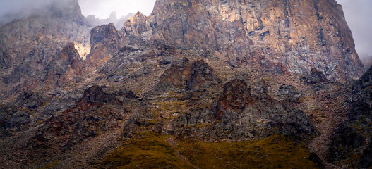 A beautiful rocky mounains in a foggy cloudy weather in the evening.