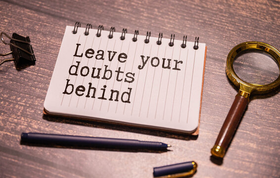 Leave your doubts behind - handwriting on a napkin with a cup of espresso coffee