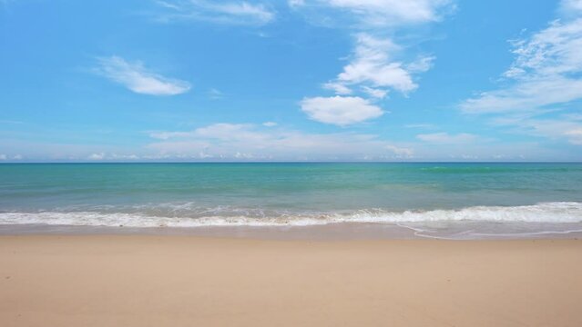 Summer sea background.Blue sky white clouds over ocean waves break on sand beach.Waves crashing against an empty beach.Sea waves and beautiful sand beach in Patong Phuket Thailand. High quality video