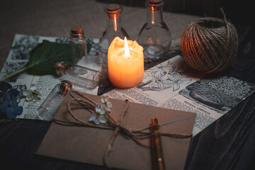 Mystical still life in vintage style with empty flasks, burning candles, letters and newspaper...