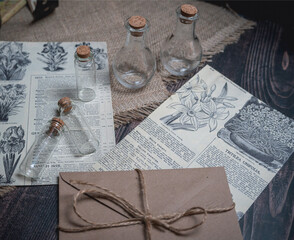 Mystical still life in vintage style with empty flasks, letters and newspaper clippings