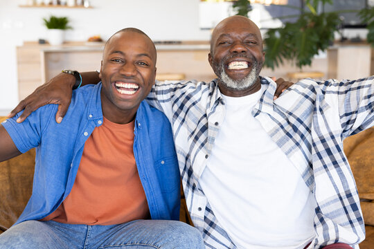 African American senior father and adult son laughing at home - Powered by Adobe