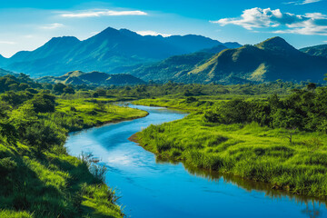 A tranquil river winding through a lush green valley, with mountains towering in the distance and a clear blue sky overhead.