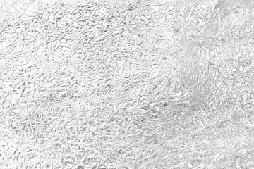 Crumpled silver foil as background, top view