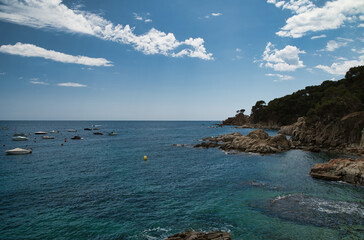 Boats anchored near the rocky beach in Calella de Palafrugell, a fishing village on the Costa Brava in Catalonia, Spain.
