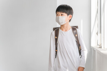 学校でマスクをつけている小学生の男の子
