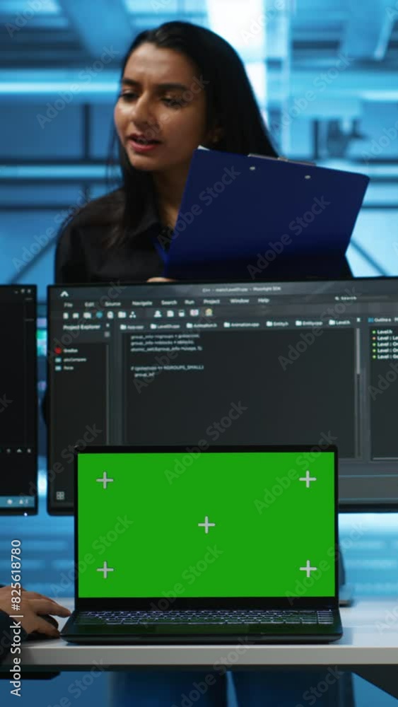 Poster vertical video green screen laptop in data center in front of manager and it support specialists wor