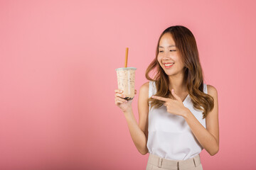 Pearl milk tea beverage concept. Asian beautiful young woman holding drinking brown sugar flavored...