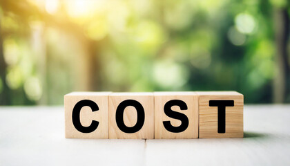 Wooden blocks spelling "COST" on a white tabletop with a blurred wall background, symbolizing financial considerations, budgeting, and expense management