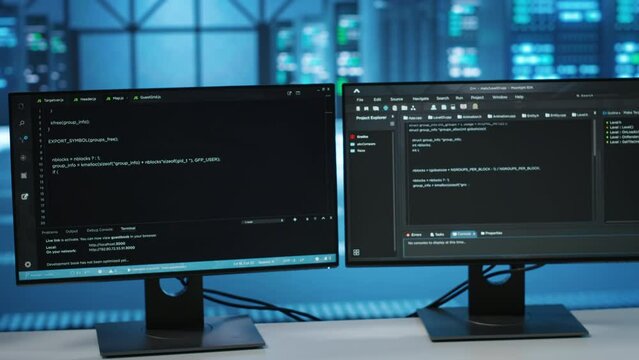 Computers in empty data center facility managing rackmounts energy consumption. Close up of script on PC monitors used for automation and monitoring processes in server room, camera B