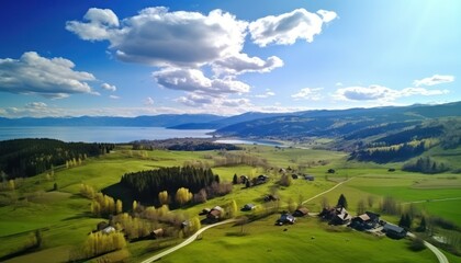 Obraz premium Stunning spring views of the countryside and green grass and beautiful flowers, with rolling hills and fertile soil, against a backdrop of vast mountains