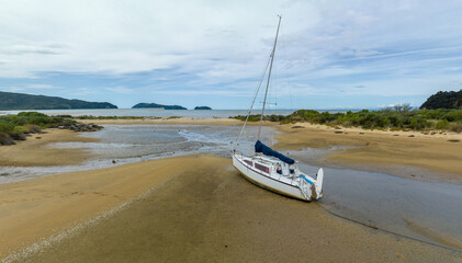 Boats morred on the sand at low tide in Sandy bay, Marahau, Motueka, Tasman, New Zealand. © Zenstratus