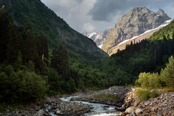 View of the Amanauz River and the way to the Devil's Mill waterfall at the foot of the mountains of the North Caucasus near the village of Dombay on a summer day, Karachay-Cherkessia, Russia