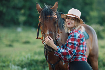 Happy blonde with horse in forest. Woman and a horse walking through the field during the day....