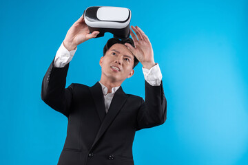Smiling Asian businessman looking through VR connecting financial business report futuristic...