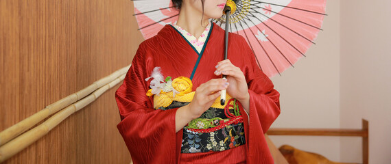 赤い着物を着て和傘をさす美女