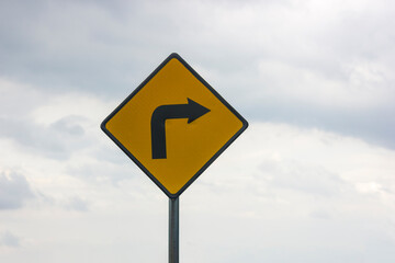 Traffic signs curve on the right isolated on cloudy sky 