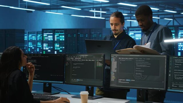 Man inspecting server farm, reading paperwork, following inspection checklist, talking with employees. Supervisor doing checkup in data center workplace, verifying reports files