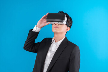Smiling Asian businessman looking thorough VR connecting to business world report in futuristic...