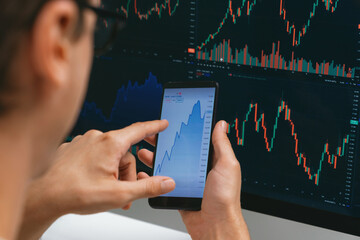 Smart stock investors pointing on screen with smartphone for market stock exchange along with...
