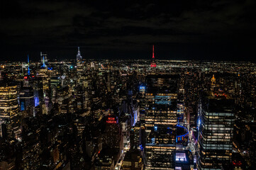 Naklejka premium Witness the awe-inspiring sprawl of Manhattan's skyscrapers from a daring perspective below. Towering giants pierce the clouds, offering a unique vantage point for travel and architecture content.