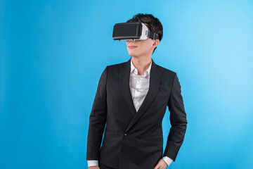 Smiling Asian businessman looking thorough VR connecting to business world report in futuristic...