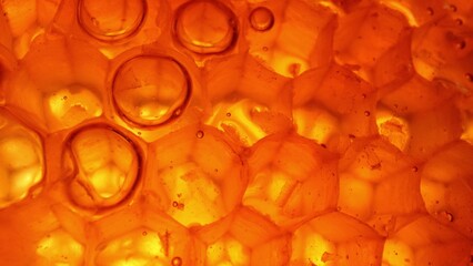 Explore the mesmerizing world of honeycomb through macro, revealing hexagonal wax cells, filled...