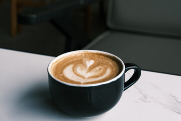 A cup of hot latte coffee on the table for breakfast
