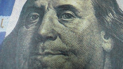 A mesmerizing close-up of the 100 dollars banknote features the timeless face of Benjamin Franklin,...