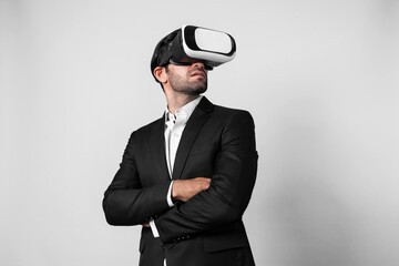 Smart business man crossing arms and standing with folded arm at white background. Professional manager looking at financial graph by using technology innovation to visit enter metaverse. Deviation.