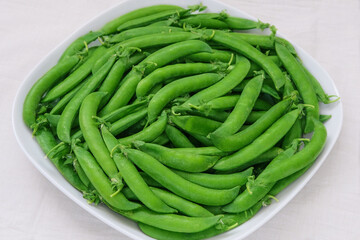 Green peas in a plate. Fresh peas in bowl. Bowls of vegetables.