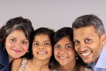 A family of four, a man and three girls, are smiling for the camera