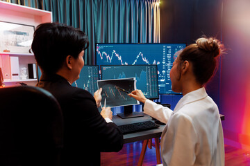 Asian businessman showing dynamic stock exchange graph paper with partner to discuss profit value...