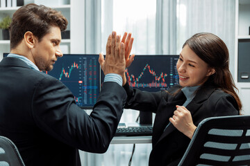 Successful in two business traders making hands high five with fist up to earn highest profit stock...