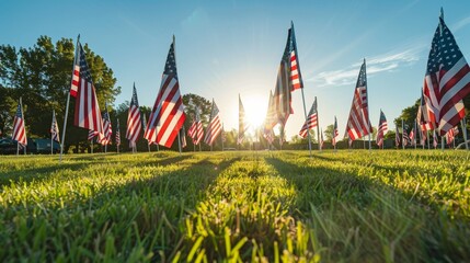 Obraz premium Rows of American flags standing tall in a grassy field, Memorial Day celebration, clear sky, bright sunshine