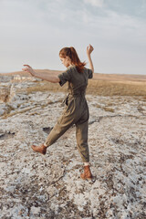 Exploring the vast desert landscape woman in green jumpsuit standing on rock in the middle of nowhere