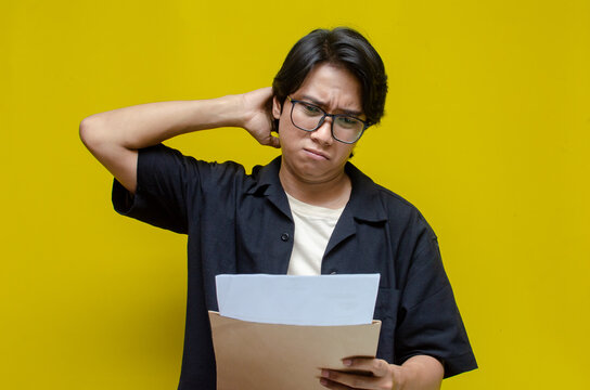 asian man opening envelope receiving and reading bad news letter. An angry man is upset over his excessive expenses, notice of termination, bank debt, and tax invoice.