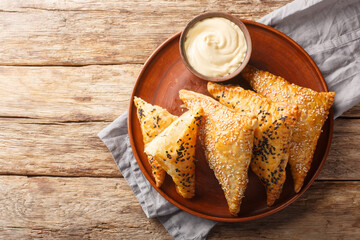 Chicken puffs with cheese and herbs served with dipping sauce close-up in a plate on a wooden...