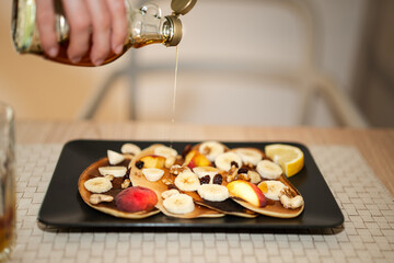 Breakfast meal. Hand holding bottle with syrup. Sweet pancakes fruit maple.