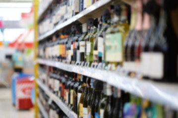 A woman shopping with a cart in a supermarket aisle full of groceries blur lens camera