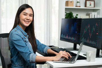 Young Asian in IT developer looking at camera to present with online information on pc with coding...