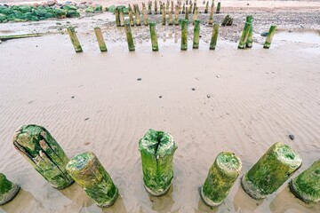 Ruined wooden pier leading towards the sea on the horizon.