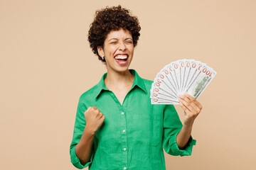 Young woman of African American ethnicity wears green shirt casual clothes hold in hand fan of cash...