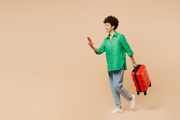 Full body traveler woman in green casual clothes hold passport ticket bag use mobile cell phone...